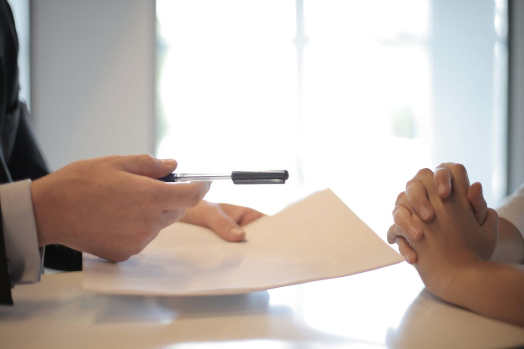 A person handing lease documents to another person